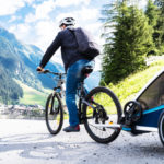 Všetky výhody a nevýhody detského cyklovozíka za bicykle