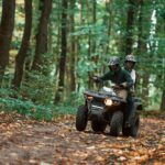 Štvorkolka jazdiaca po lesnej ceste s dôrazom na ekologický štýl jazdy.