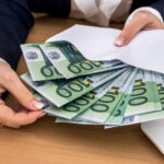 Účtovník pracujúci s finančnými dokumentmi a notebookom.