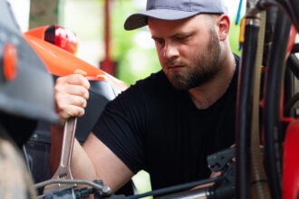 Majiteľ kontroluje a pripravuje štvorkolku na sezónu v garáži, vykonáva základnú údržbu a servis.