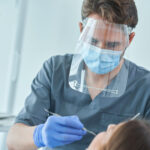 Dentálna hygienička vykonávajúca profesionálne čistenie zubov pacientovi v ambulancii.