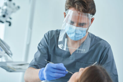 Dentálna hygienička vykonávajúca profesionálne čistenie zubov pacientovi v ambulancii.